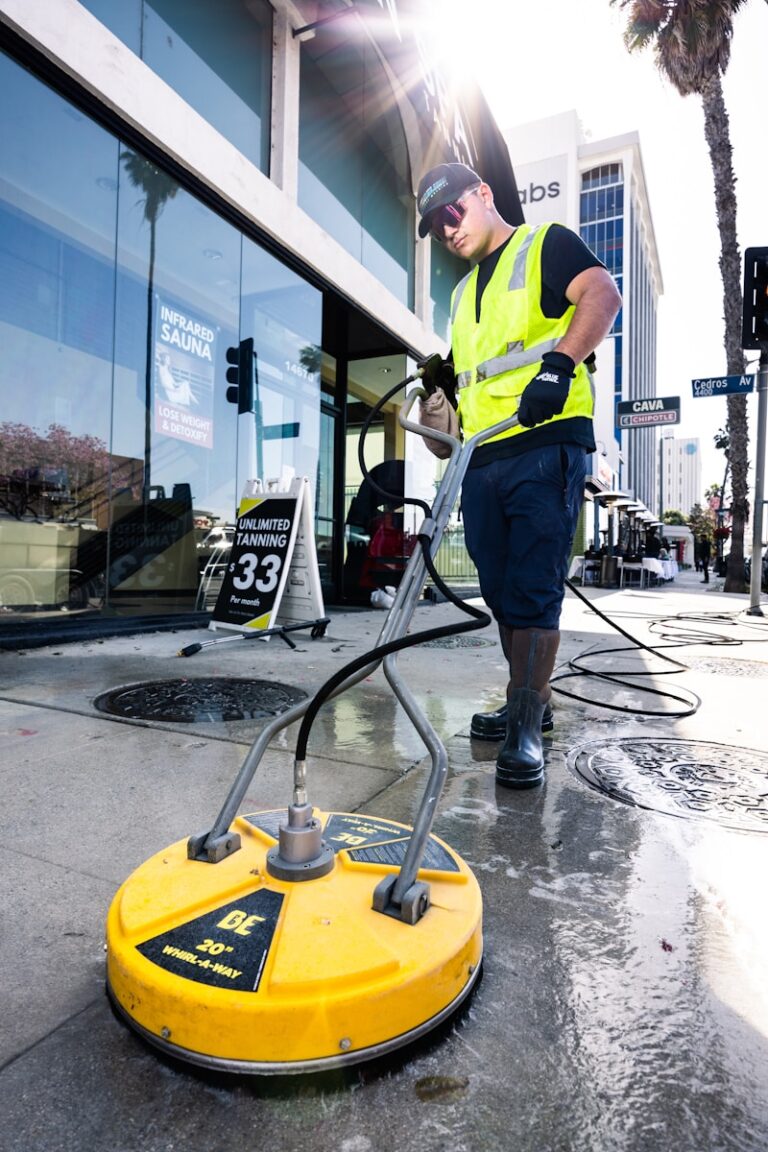 a man in a yellow vest is cleaning the street